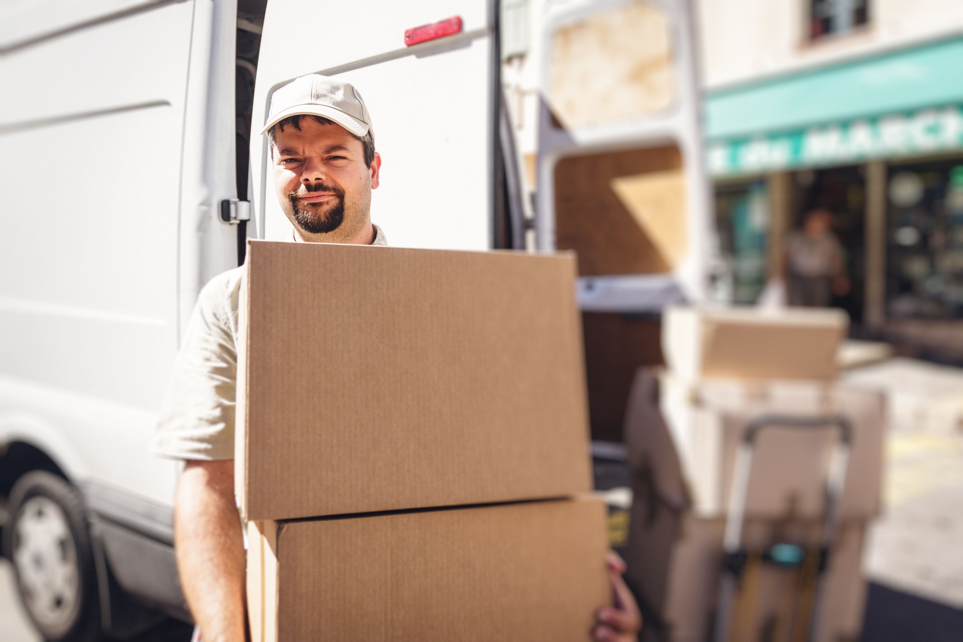 Messenger delivering parcel, standing next to his van